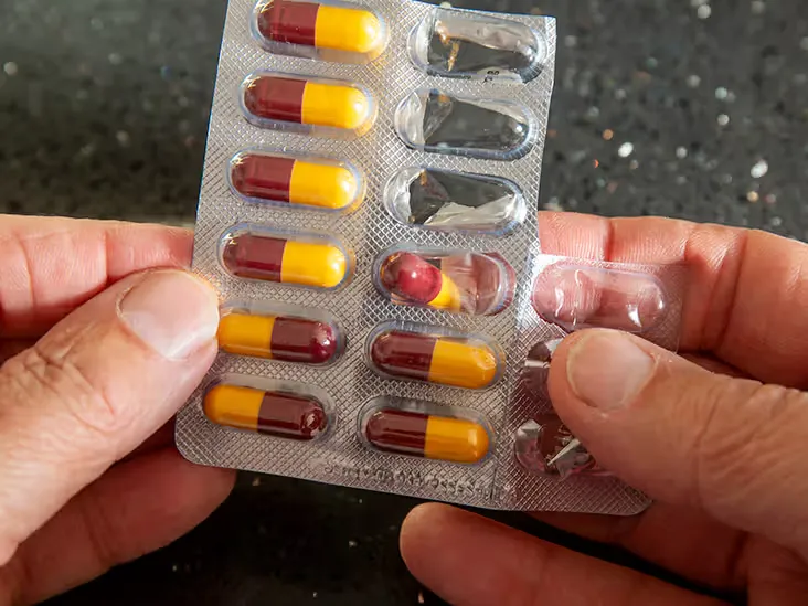 Hand holding a blister pack of amoxicillin capsules