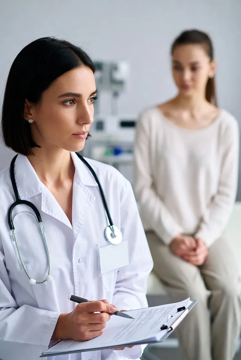 Doctor taking notes while talking with a patient in a clinic